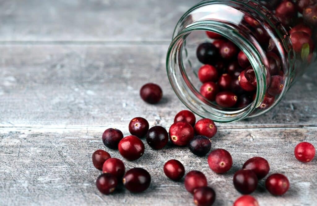 red round fruits in clear glass jar