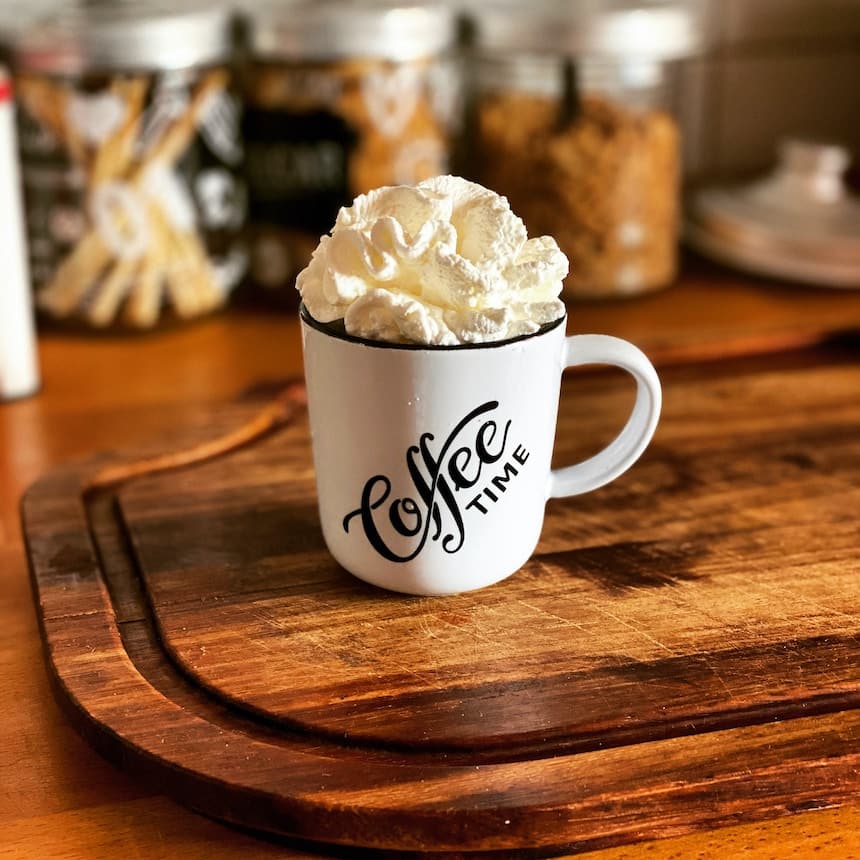 white ceramic mug with white cream on brown wooden table